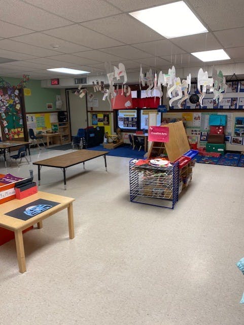 Classroom with tables, chairs, and children's artwork