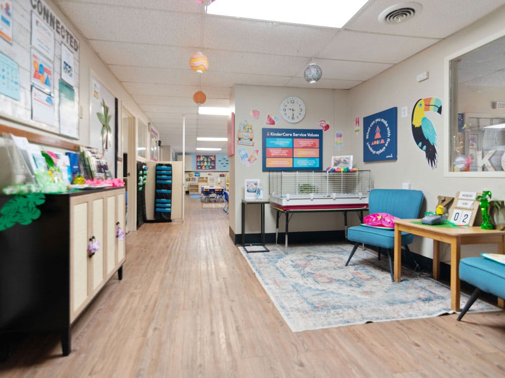Hallway in a childcare center with a sitting area and bulletin boards