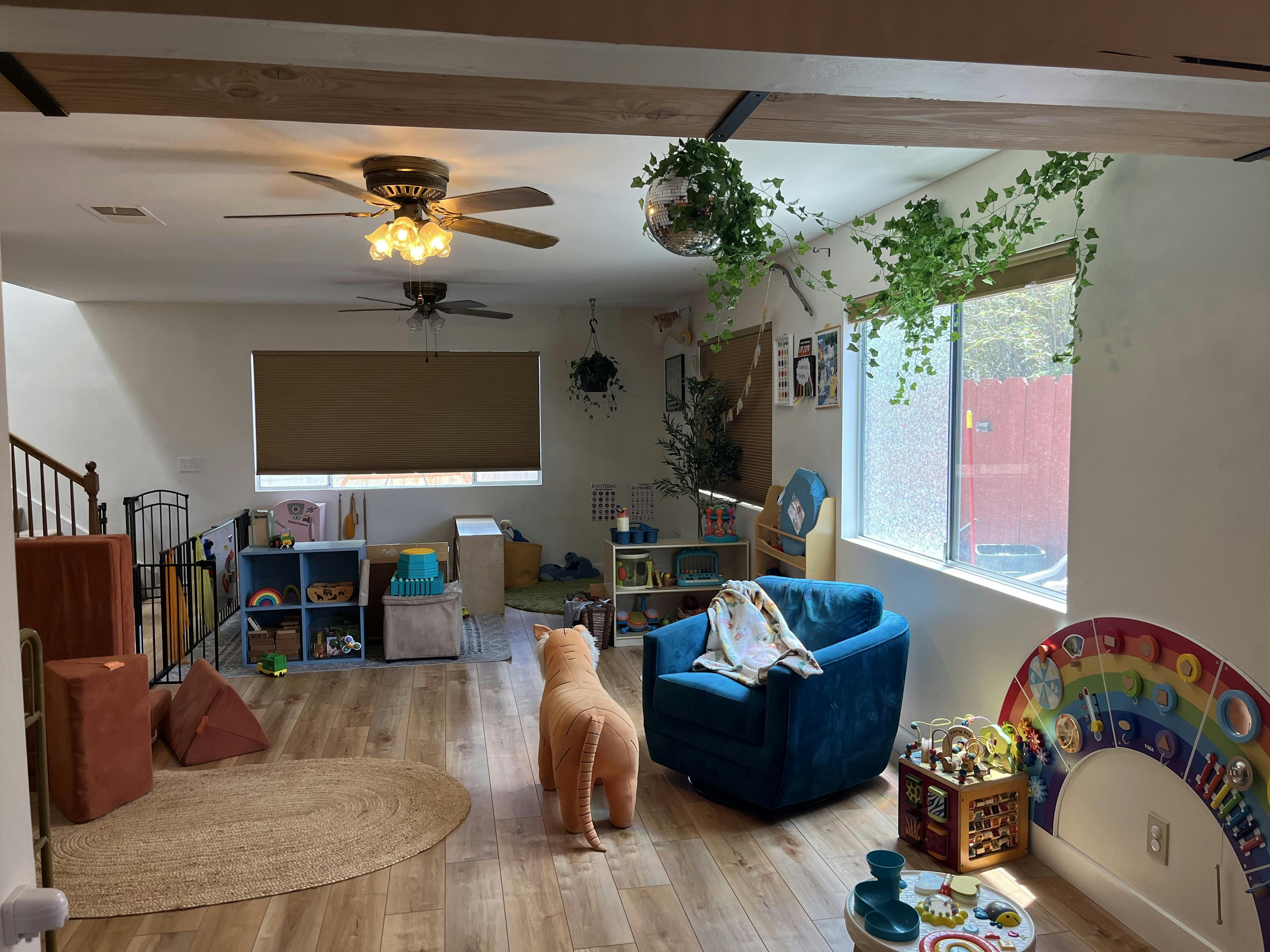 Living room with a blue armchair, a toy animal, and a large window