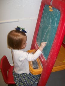 Child drawing on a chalkboard