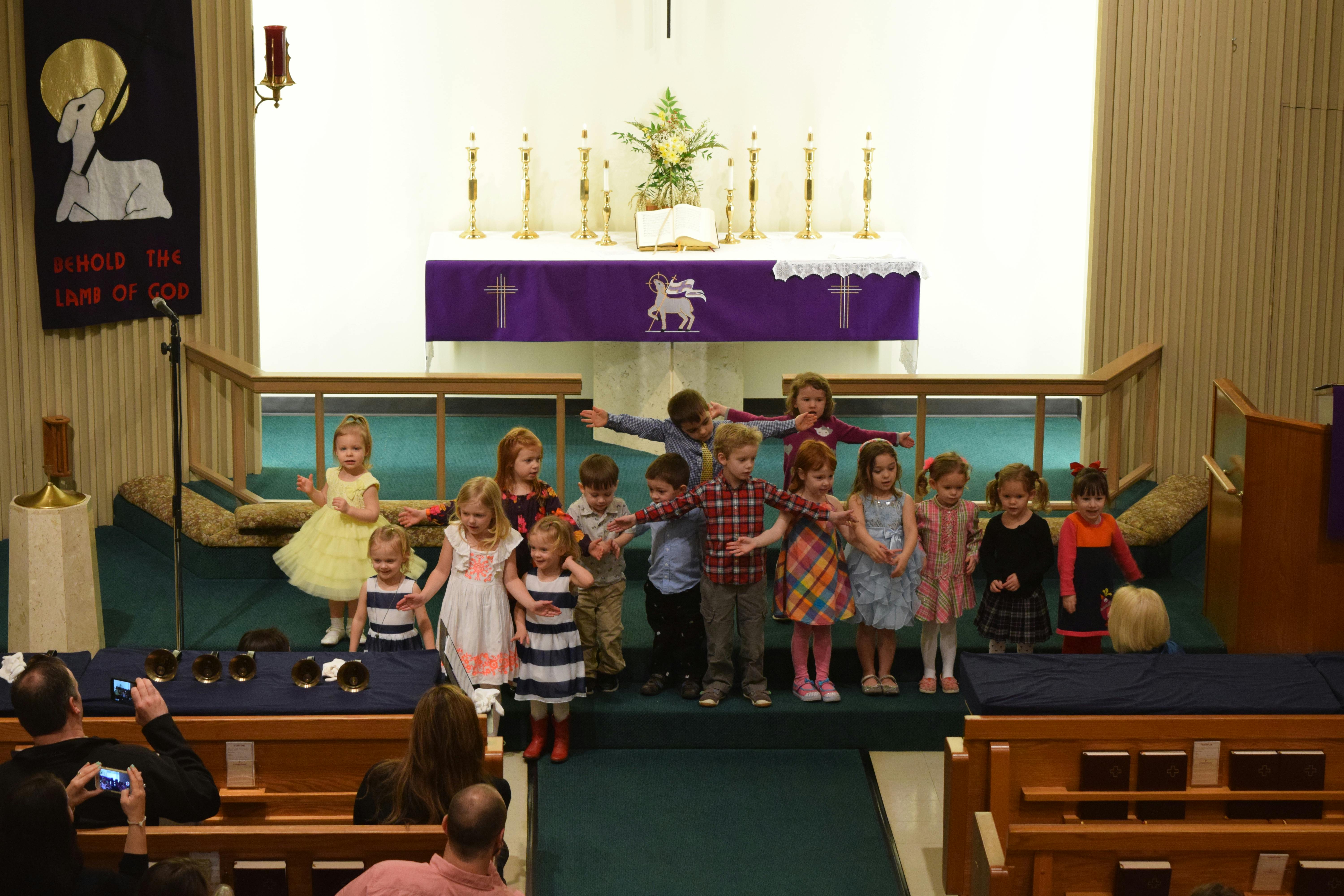 Group of children standing on a stage in a church
