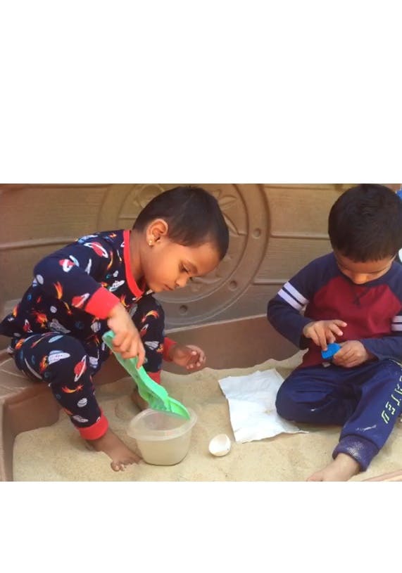 Two children playing in a sandbox