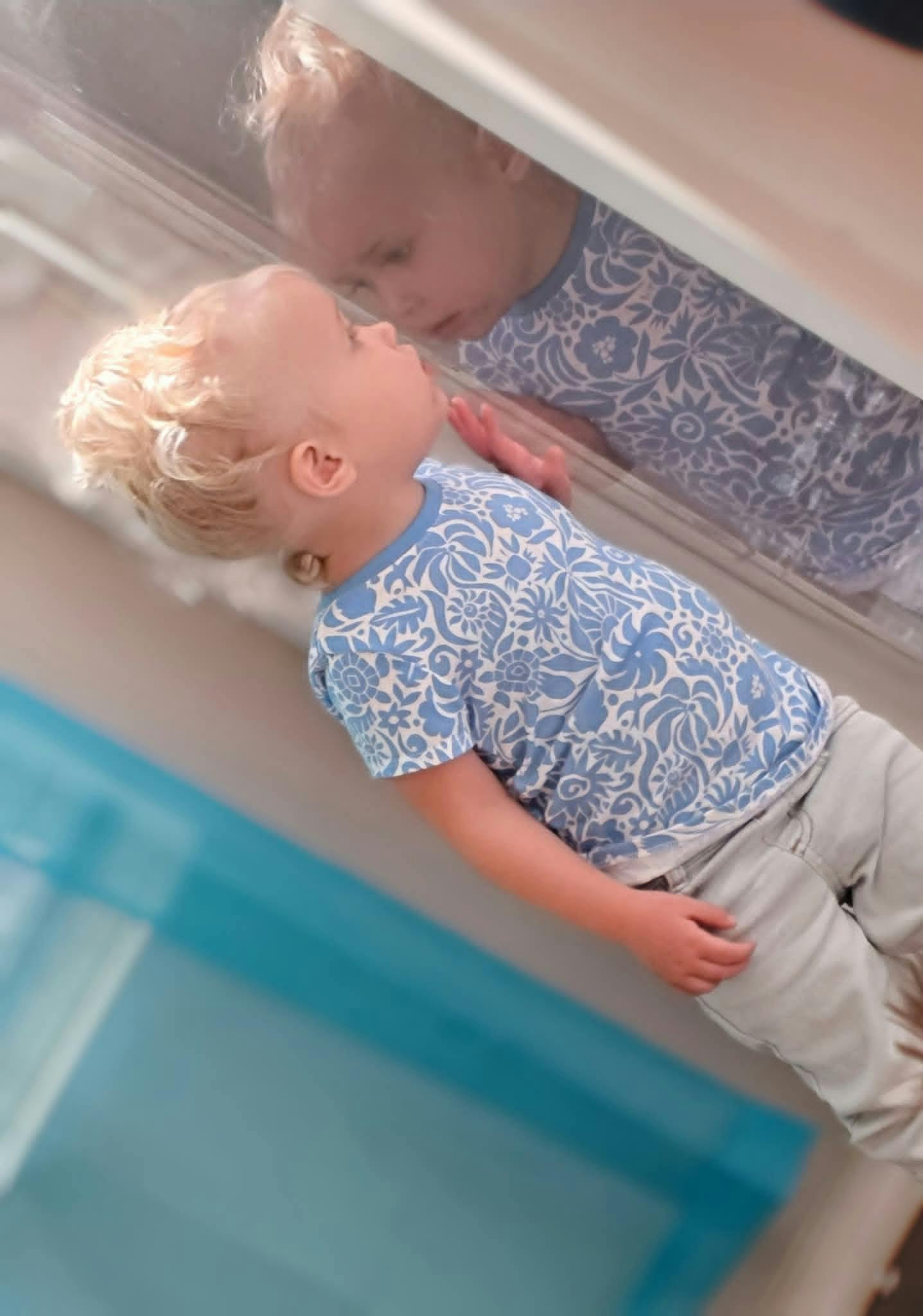Child looking at their reflection in a mirror