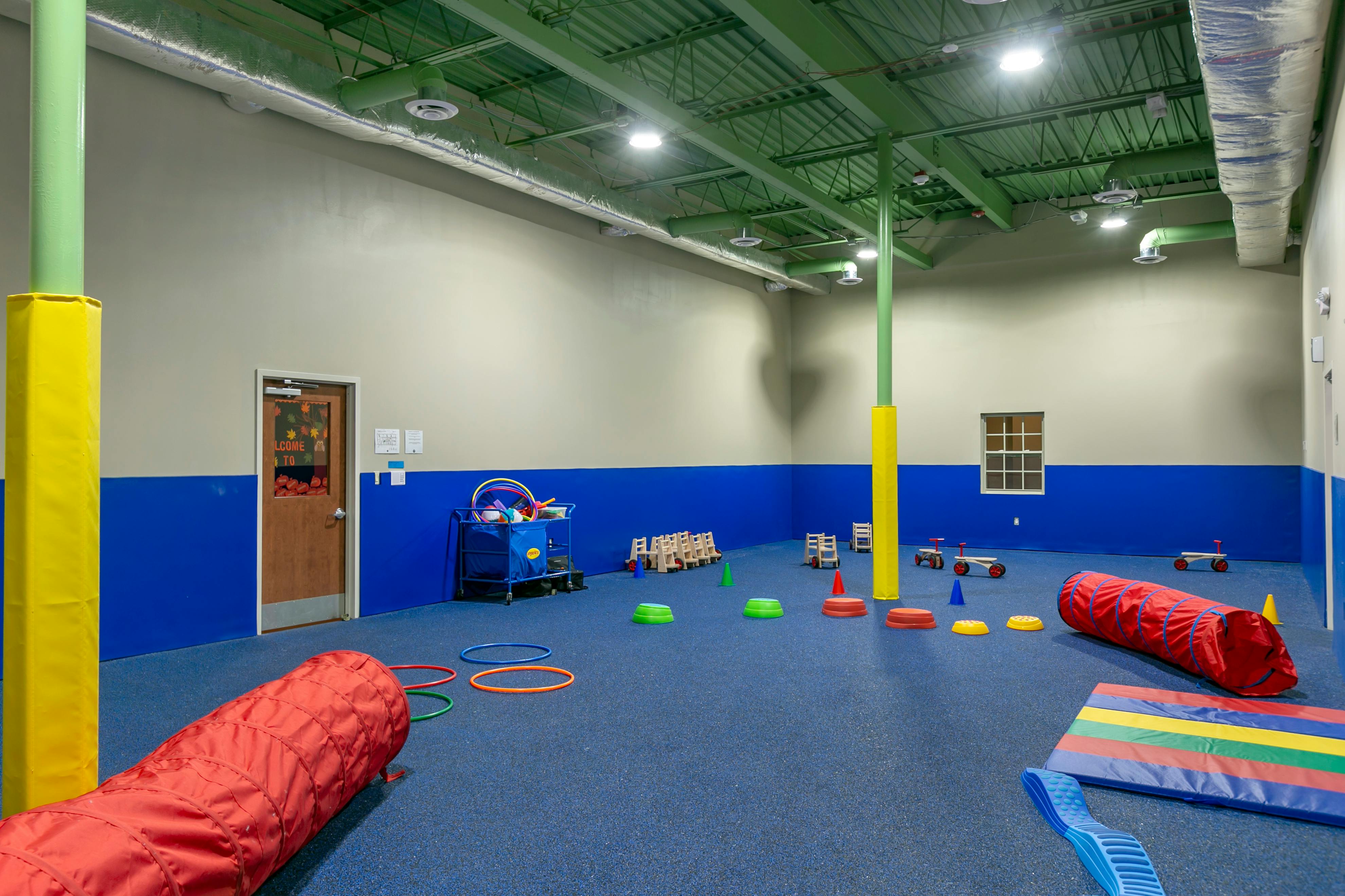 Indoor play area with tunnels, hoops, and balance toys