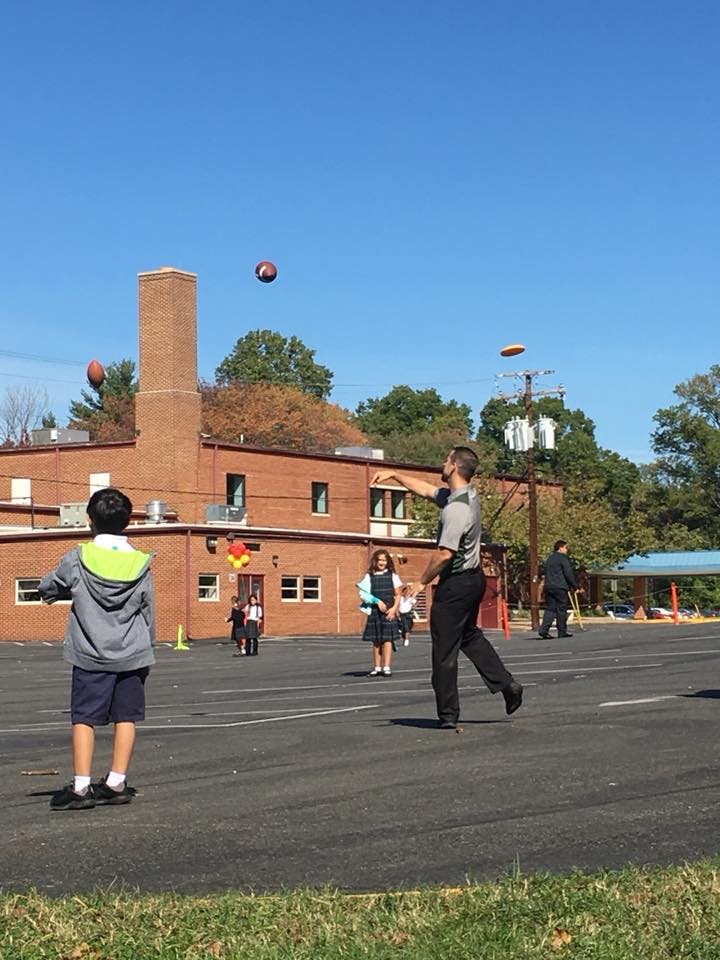 Person throwing a frisbee and footballs in the air with children nearby