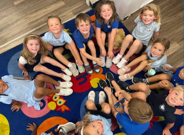 Group of children sitting in a circle on a colorful rug