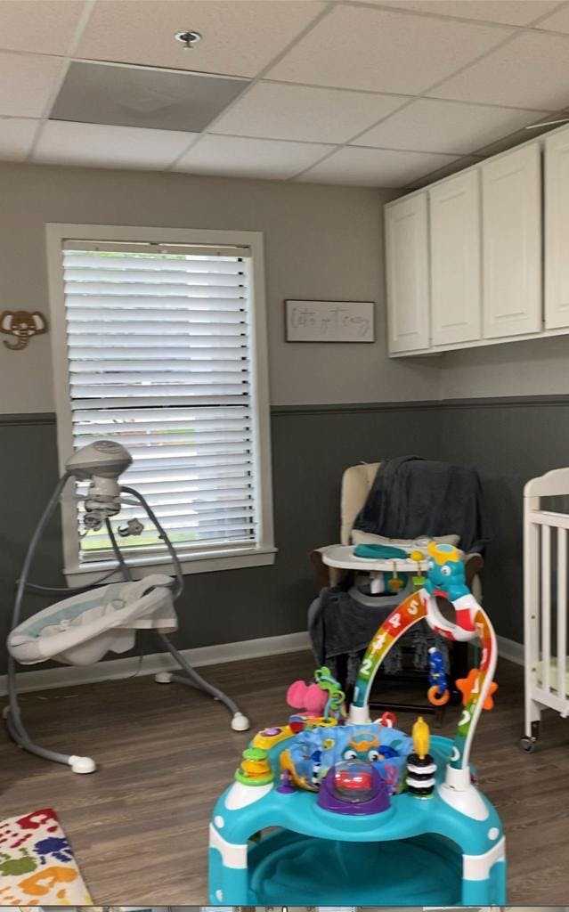 Baby swing, high chair, and activity center in a room