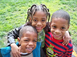 Three children smiling at the camera