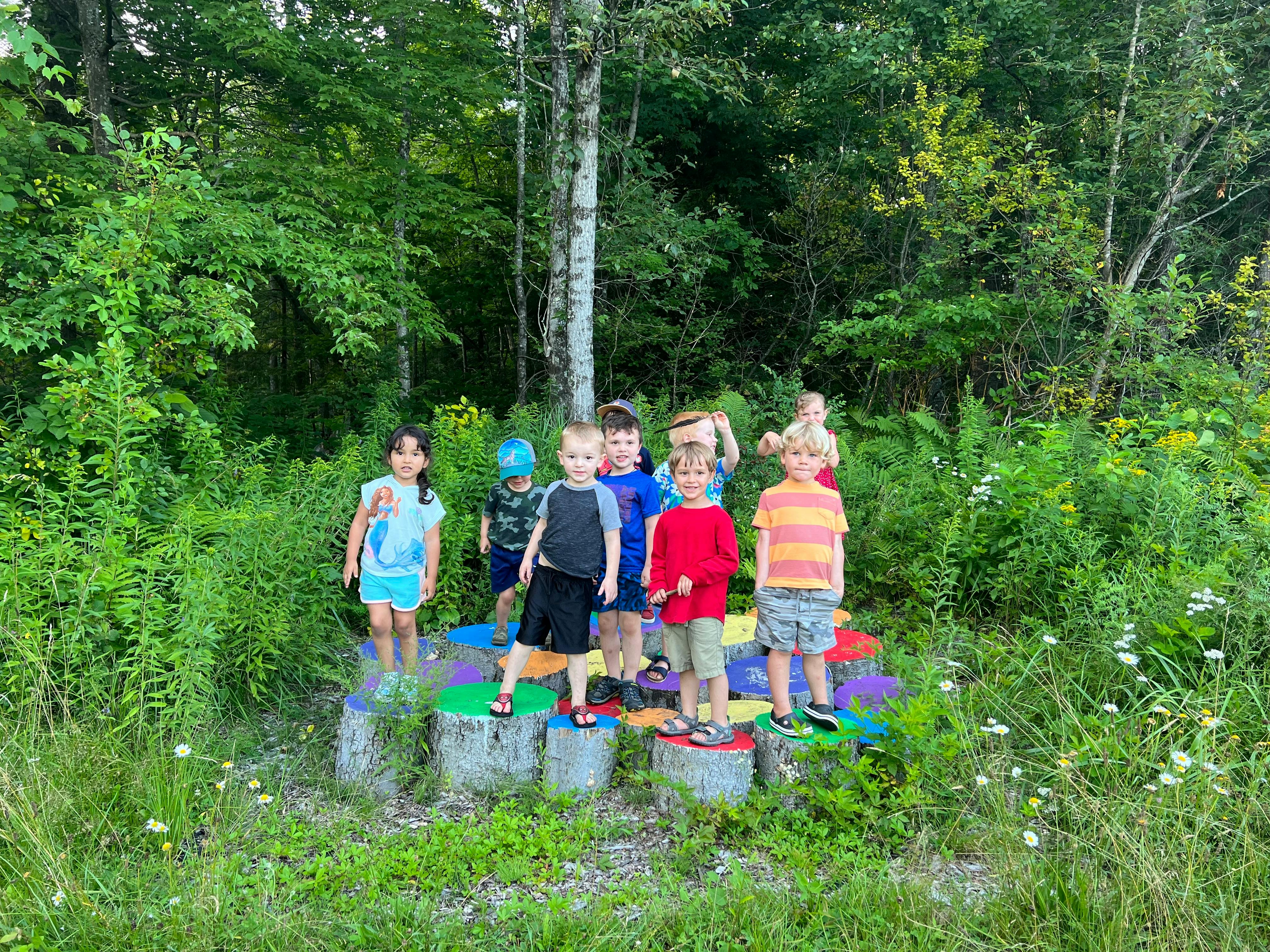 Group of children standing on colorful platforms outdoors