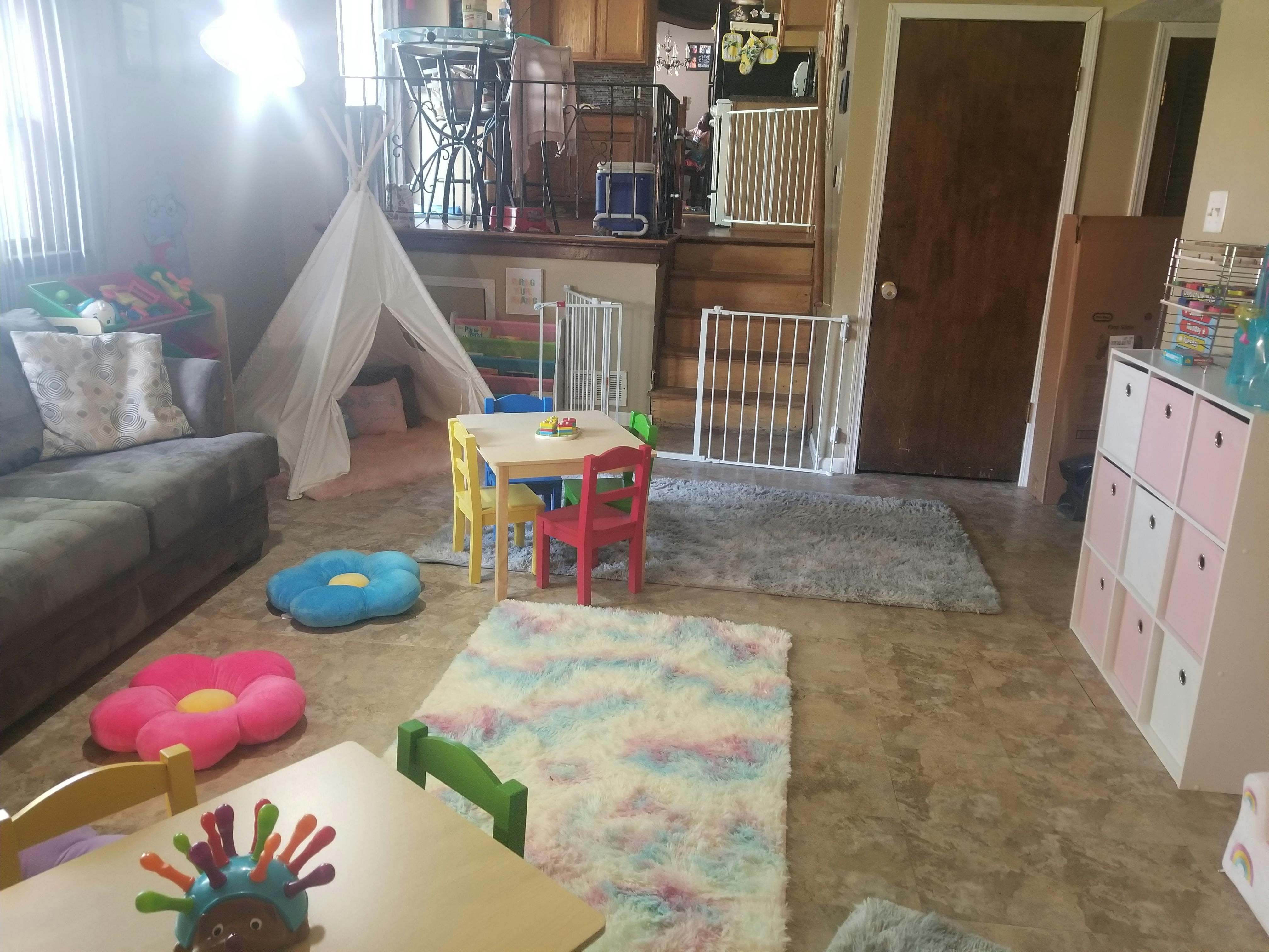 Playroom with small tables and chairs, a sofa, and a teepee