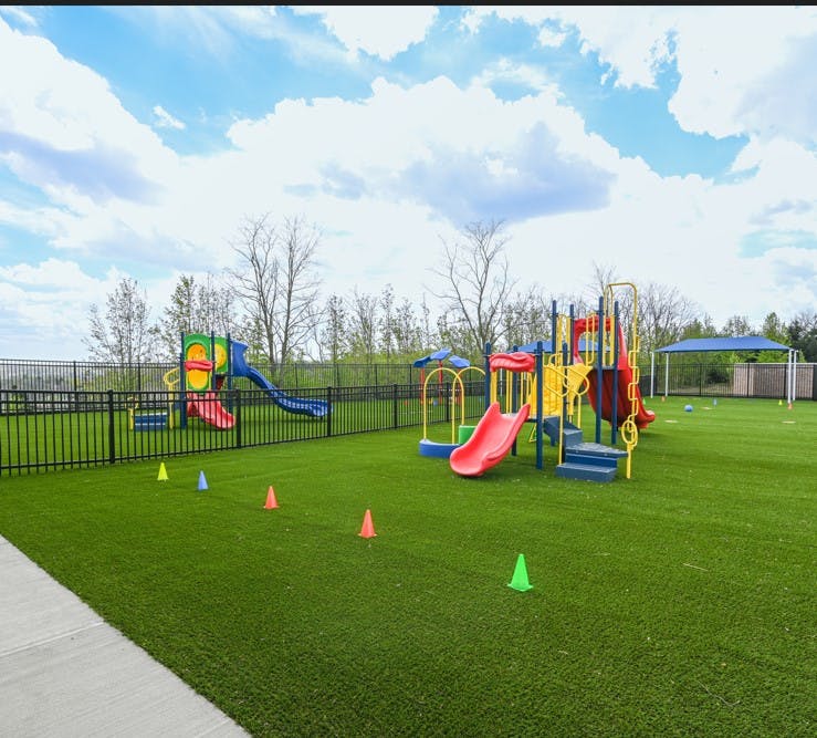 Colorful outdoor playground with multiple slides on artificial turf