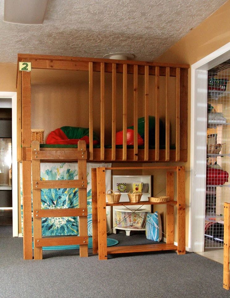 Wooden bunk bed with a ladder and a play area underneath