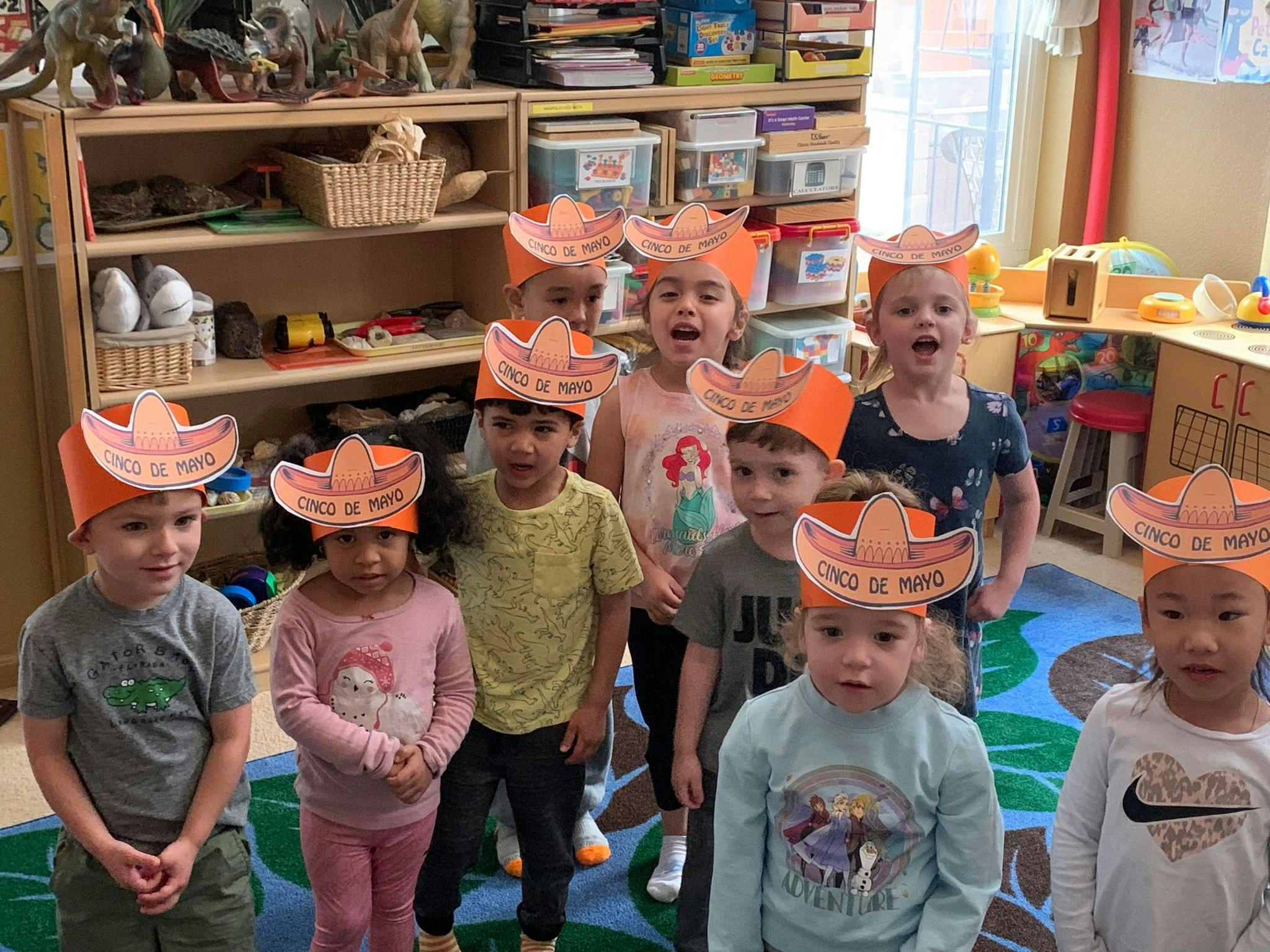 Group of children wearing paper sombrero hats in a classroom