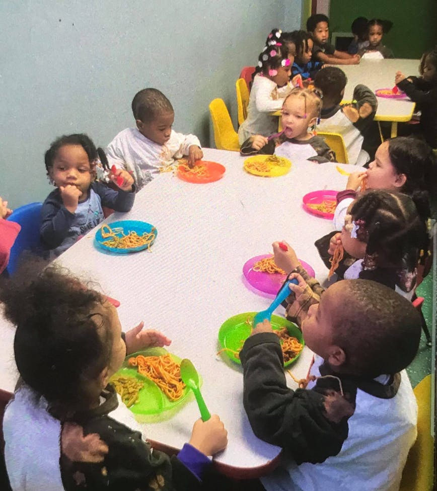 Children eating at a table in a classroom