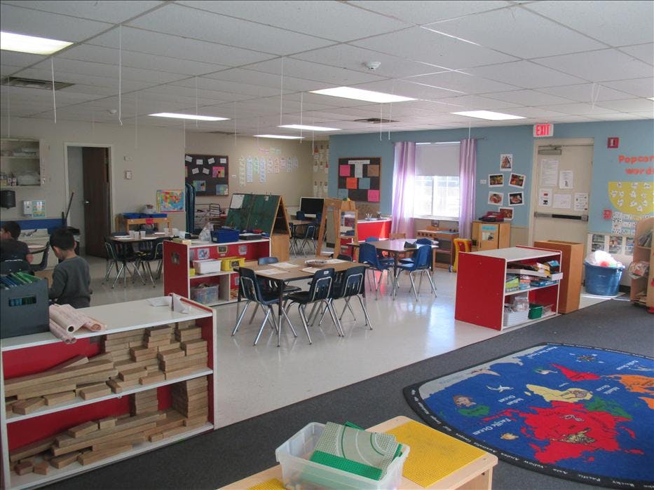 Children sitting at tables in a brightly lit classroom
