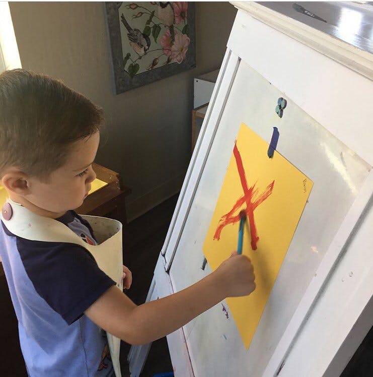 Child painting on an easel