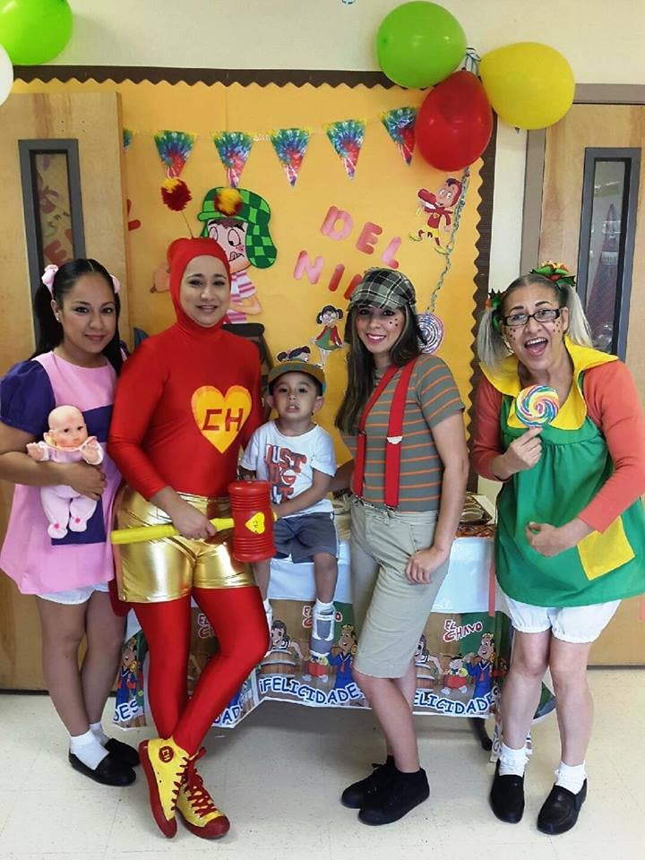 Four adults and one child in costumes posing for a photo