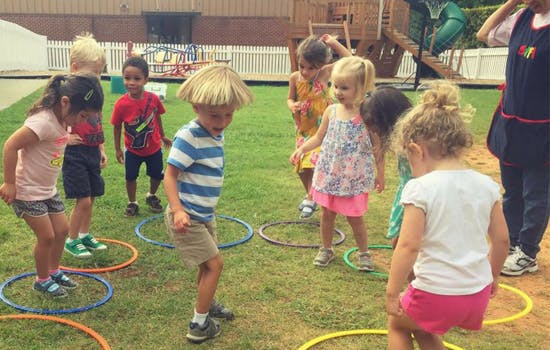 Children playing with hula hoops on grass