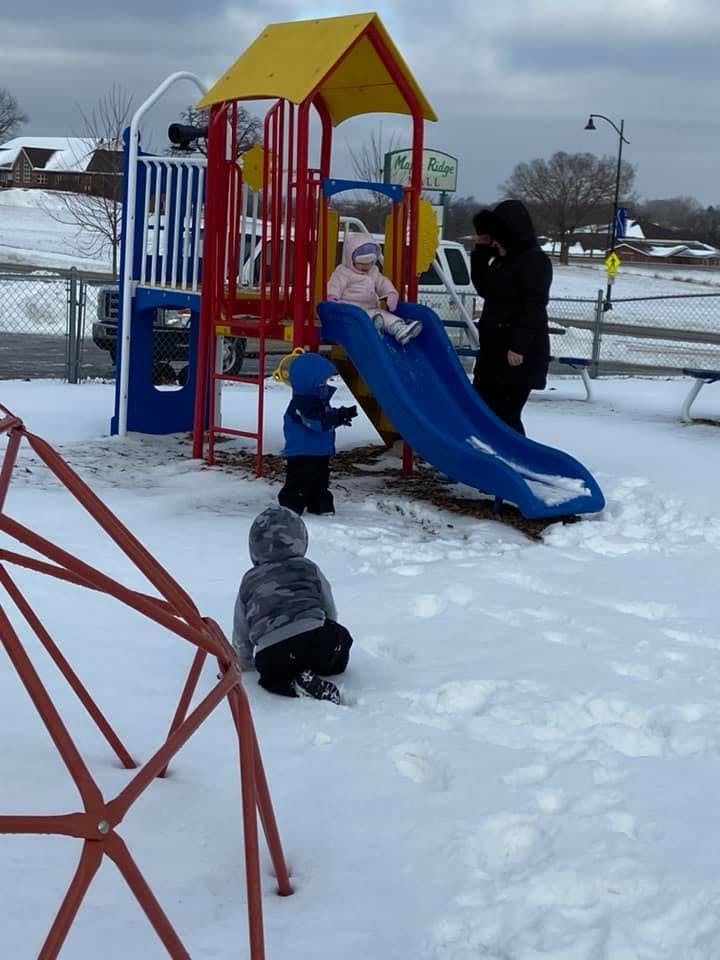 Adult and children on a snowy playground