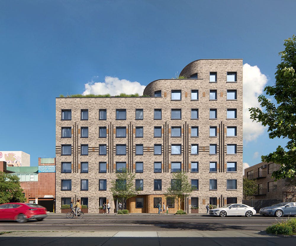 Multistory brick building with rows of windows and a green roof