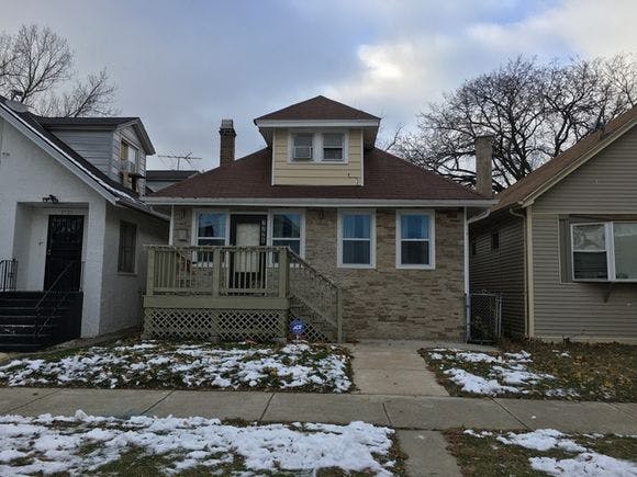 House with a front porch and steps, with snow on the ground