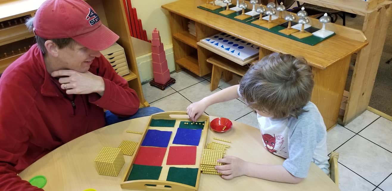 Person and child playing with colorful blocks and counting rods