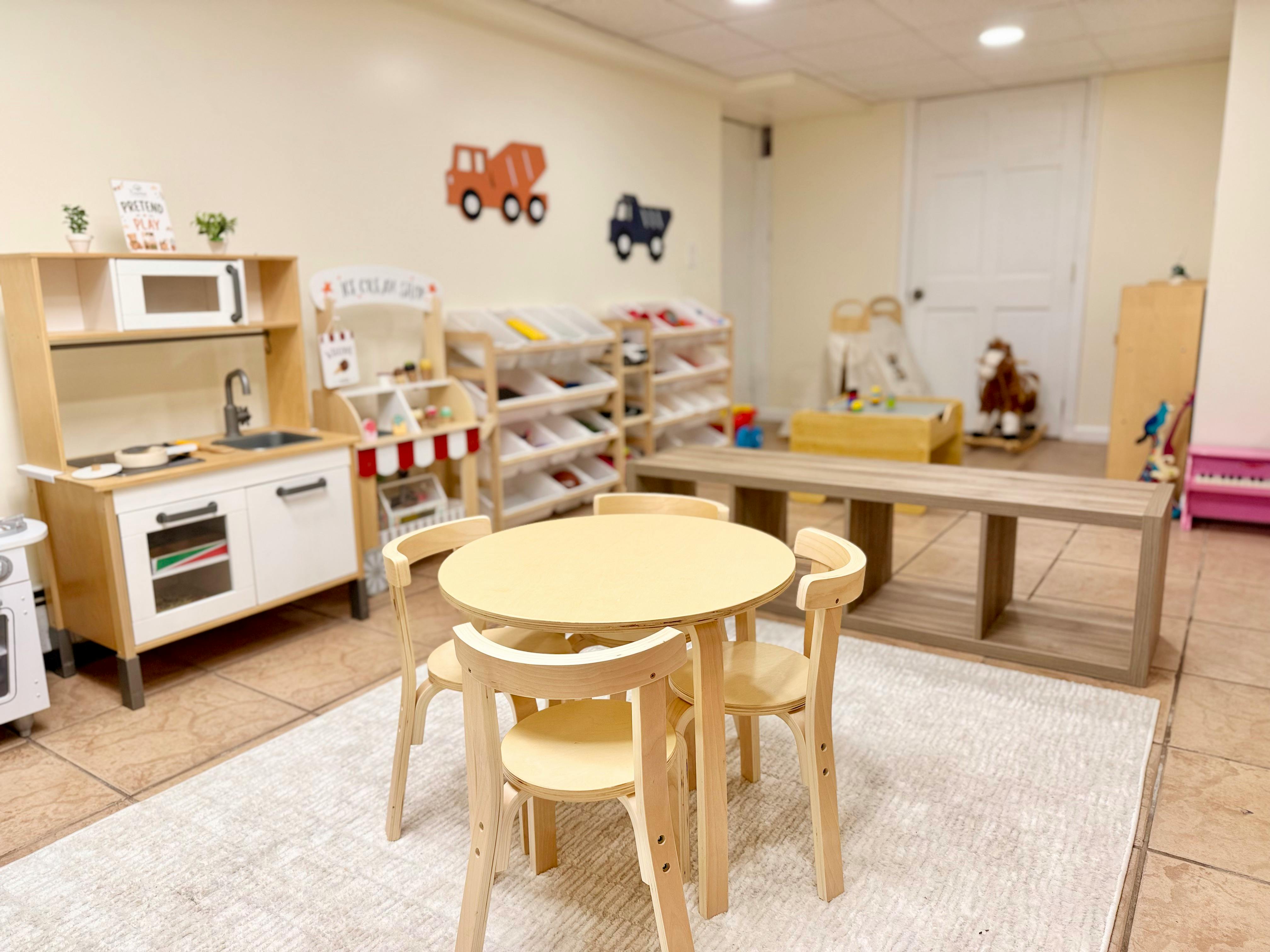 Small round wooden table and chairs in a children's play area