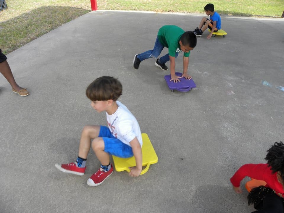 Children playing with scooter boards outdoors