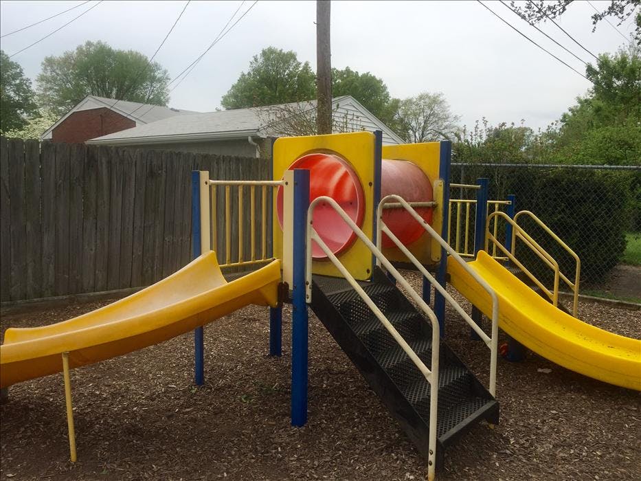 A colorful playground with yellow slides and red tunnels