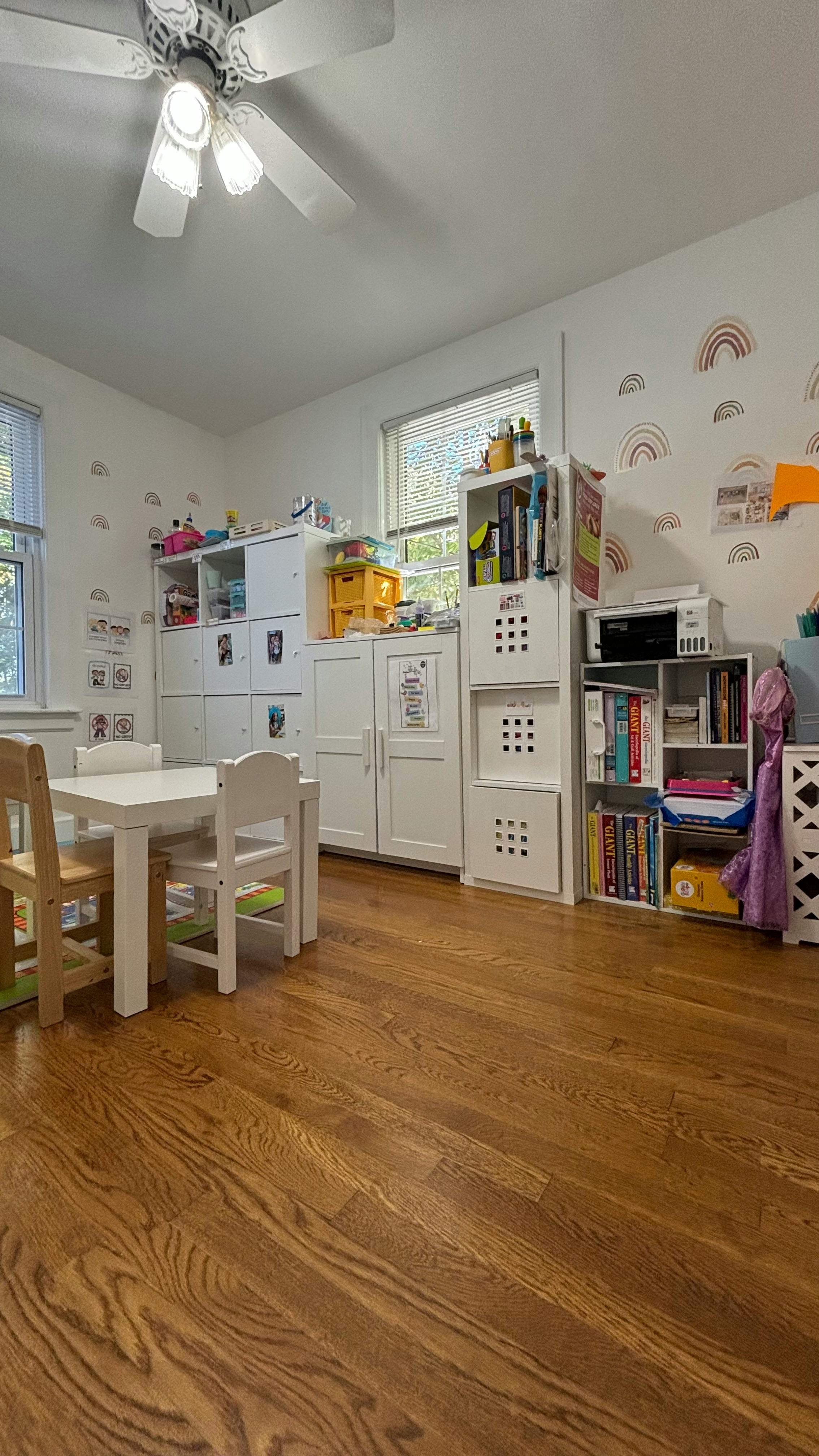 Room with small table and chairs, storage units, and bookshelves