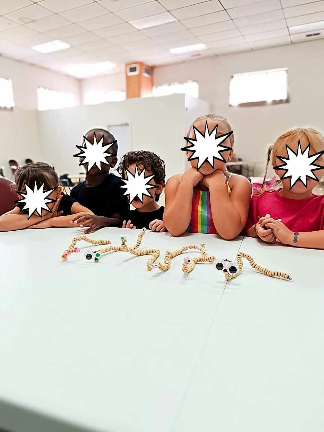 Children at a table with pipe cleaner crafts