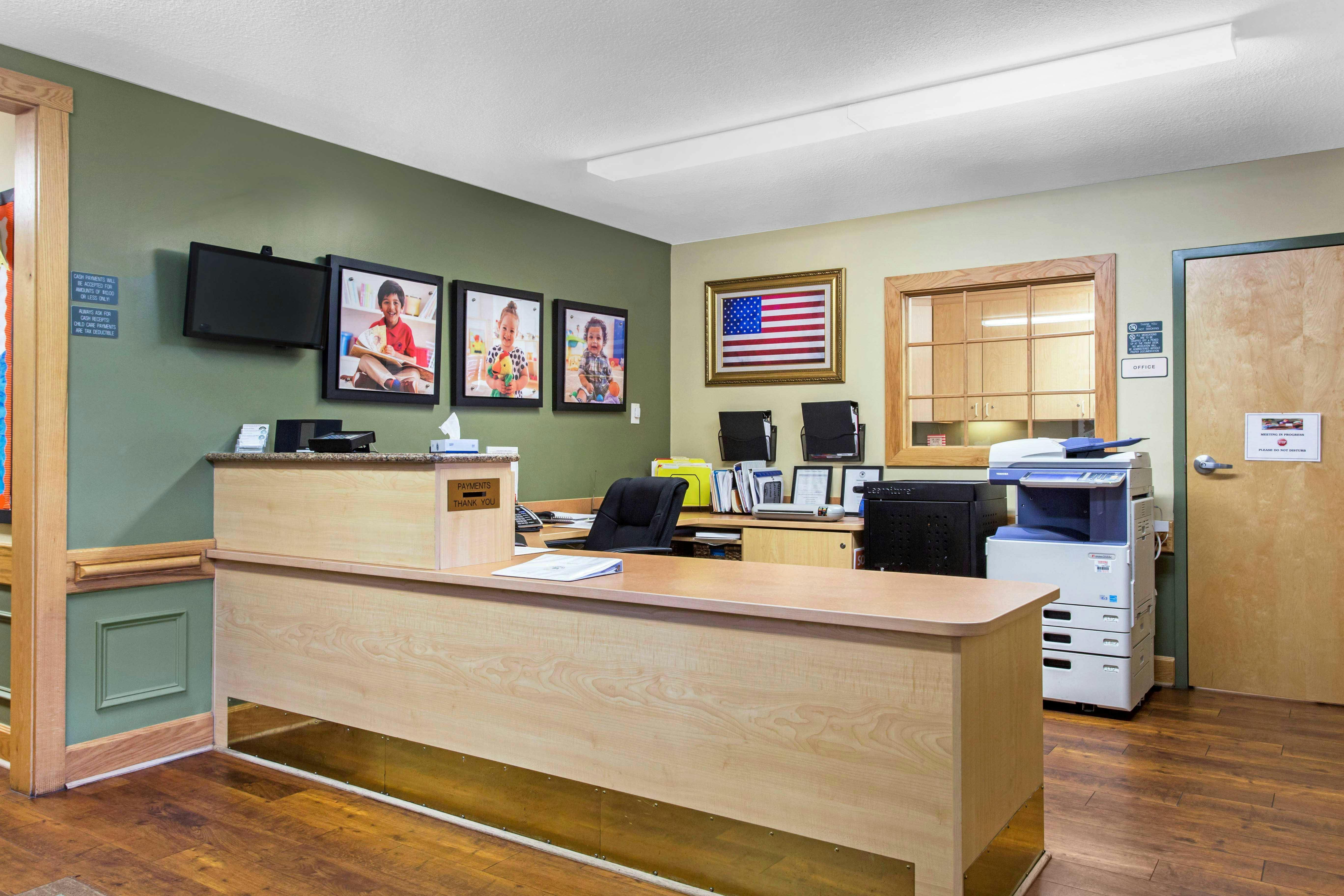 Reception desk with office equipment and framed pictures on the wall