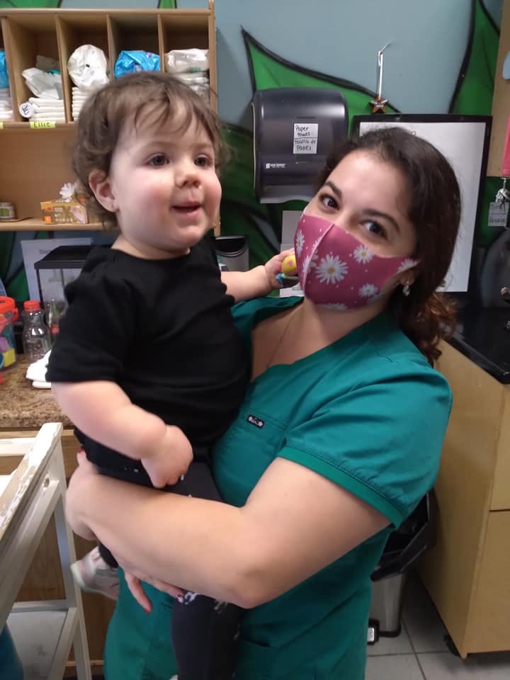 Person in a mask holding a child