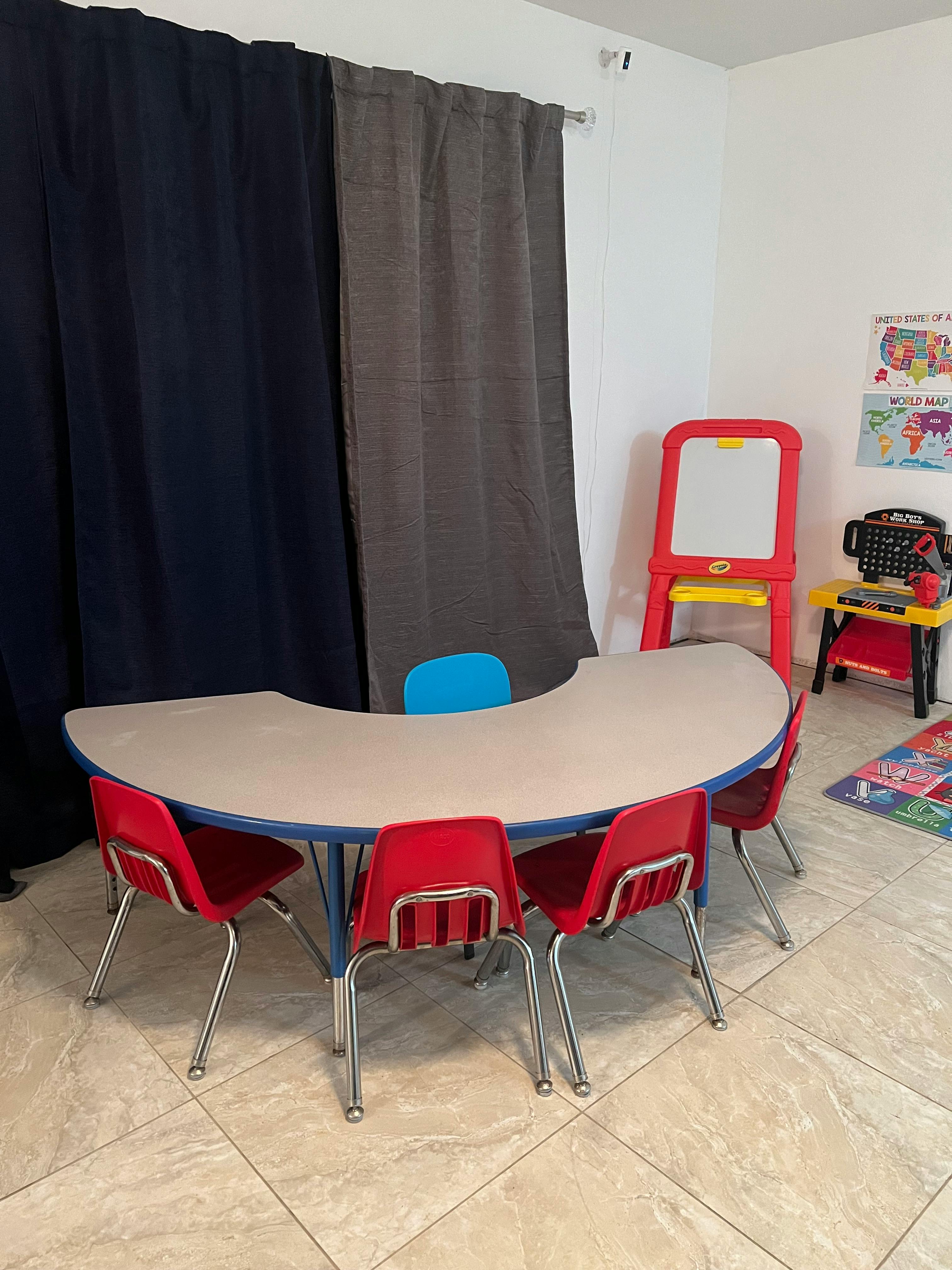 Classroom with a crescent-shaped table and red chairs