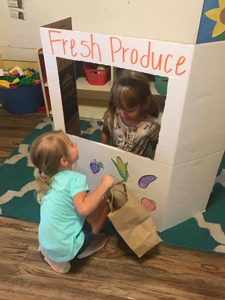 Child buying from another child at a "Fresh Produce" stand