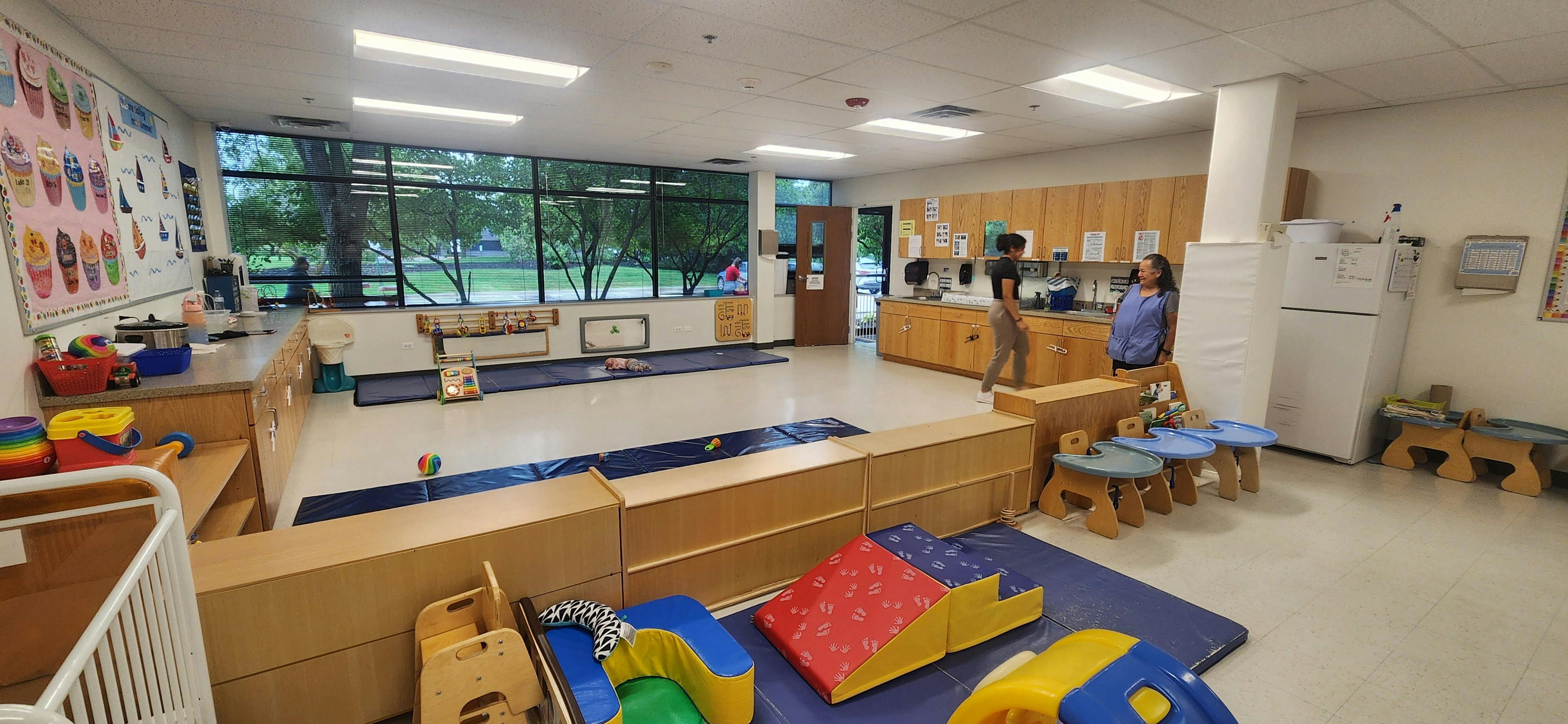 Two people in a classroom with play equipment
