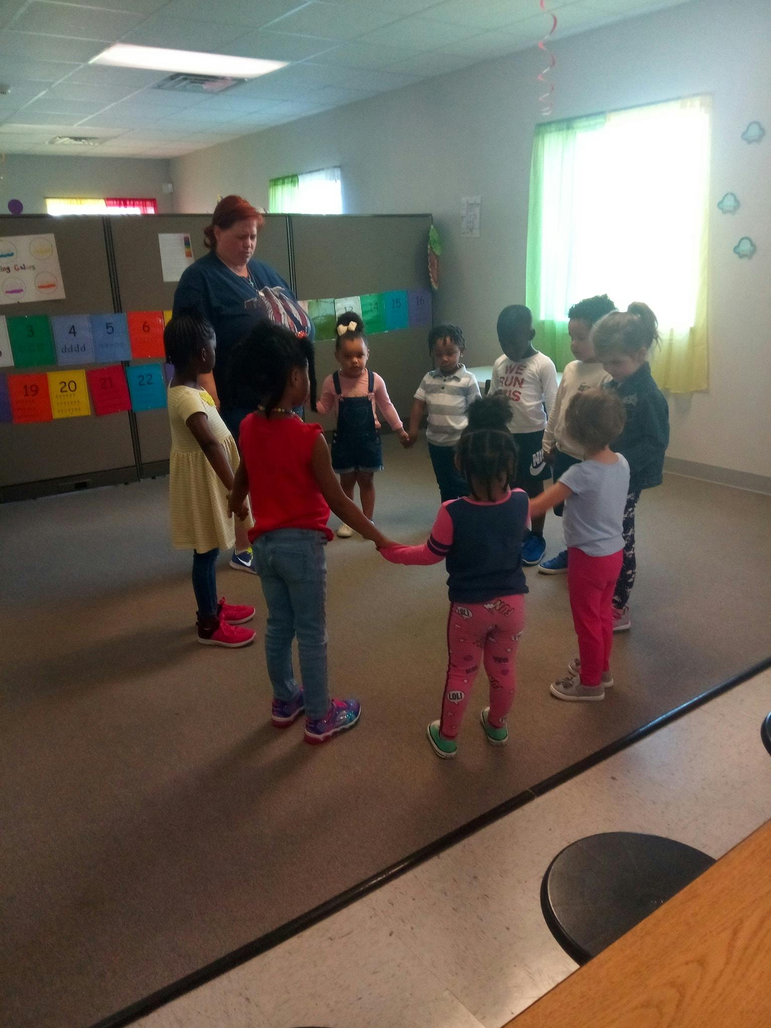 Adult and children holding hands in a circle