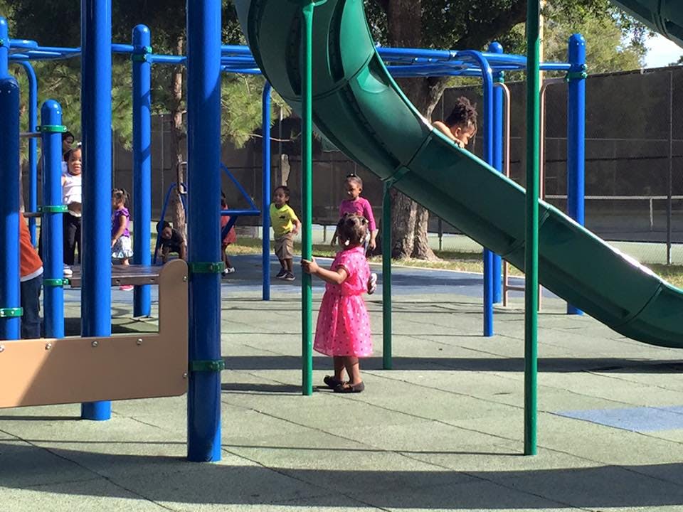 Children playing on a playground with slides and climbing structures