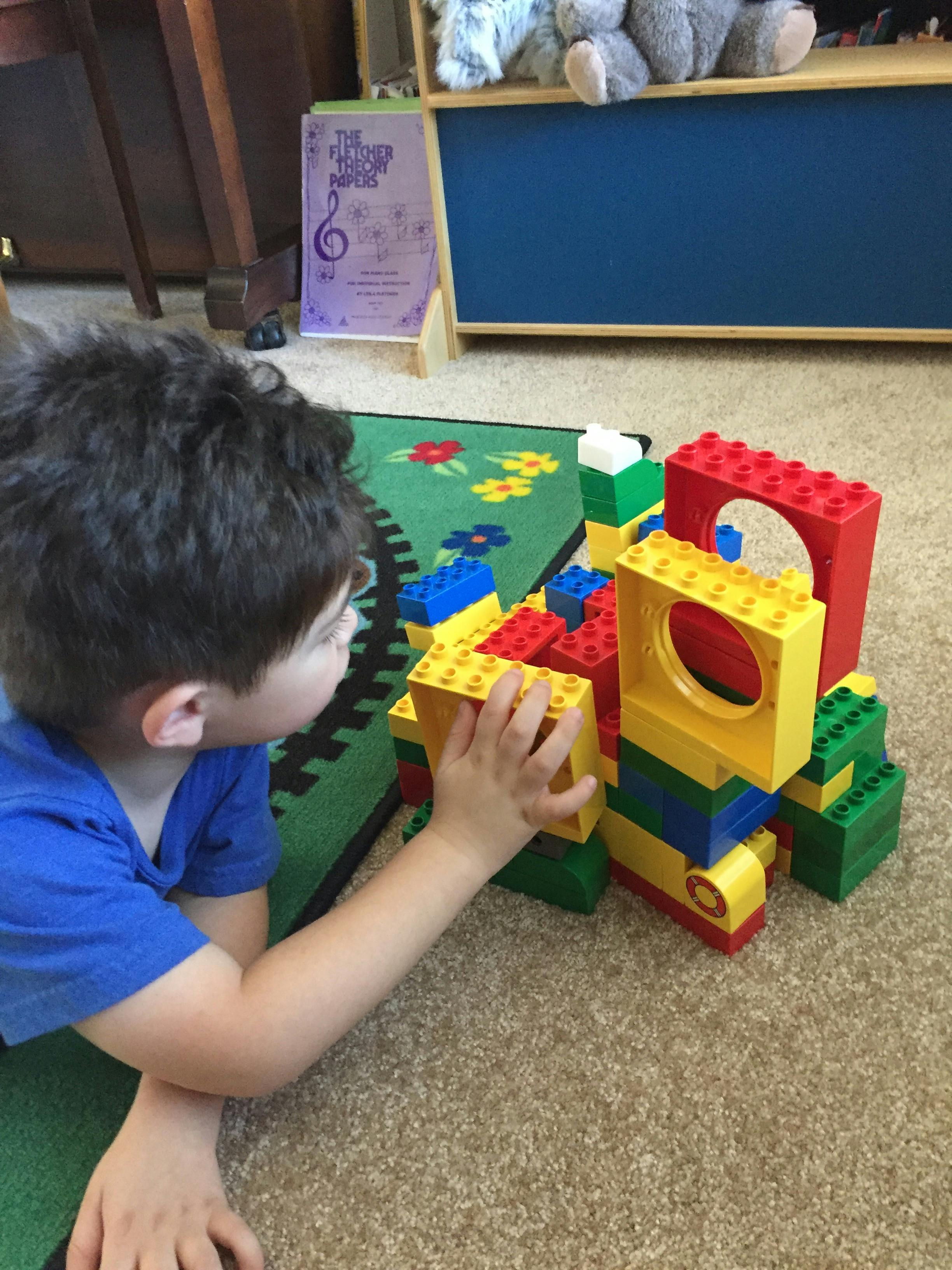 Child playing with colorful building blocks on a rug