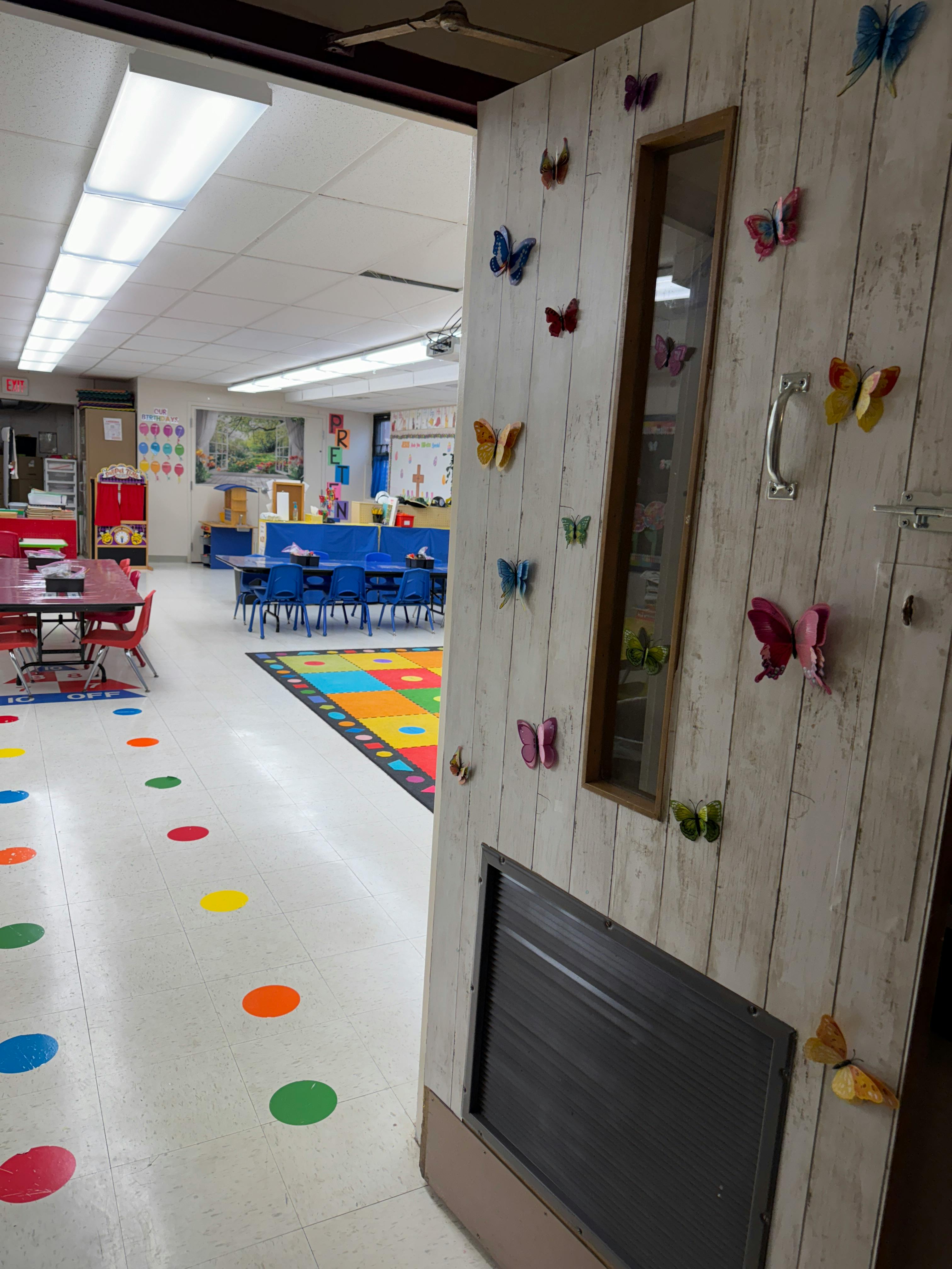 Classroom with colorful floor dots and butterfly decorations on a door