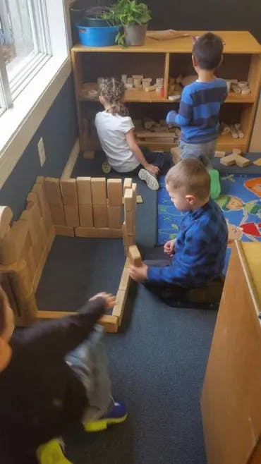 Children playing with wooden blocks in a room