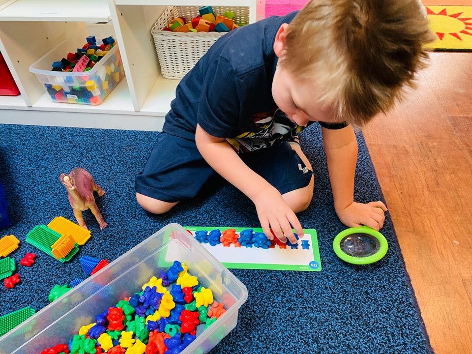 Child playing with colorful counting bears on a mat