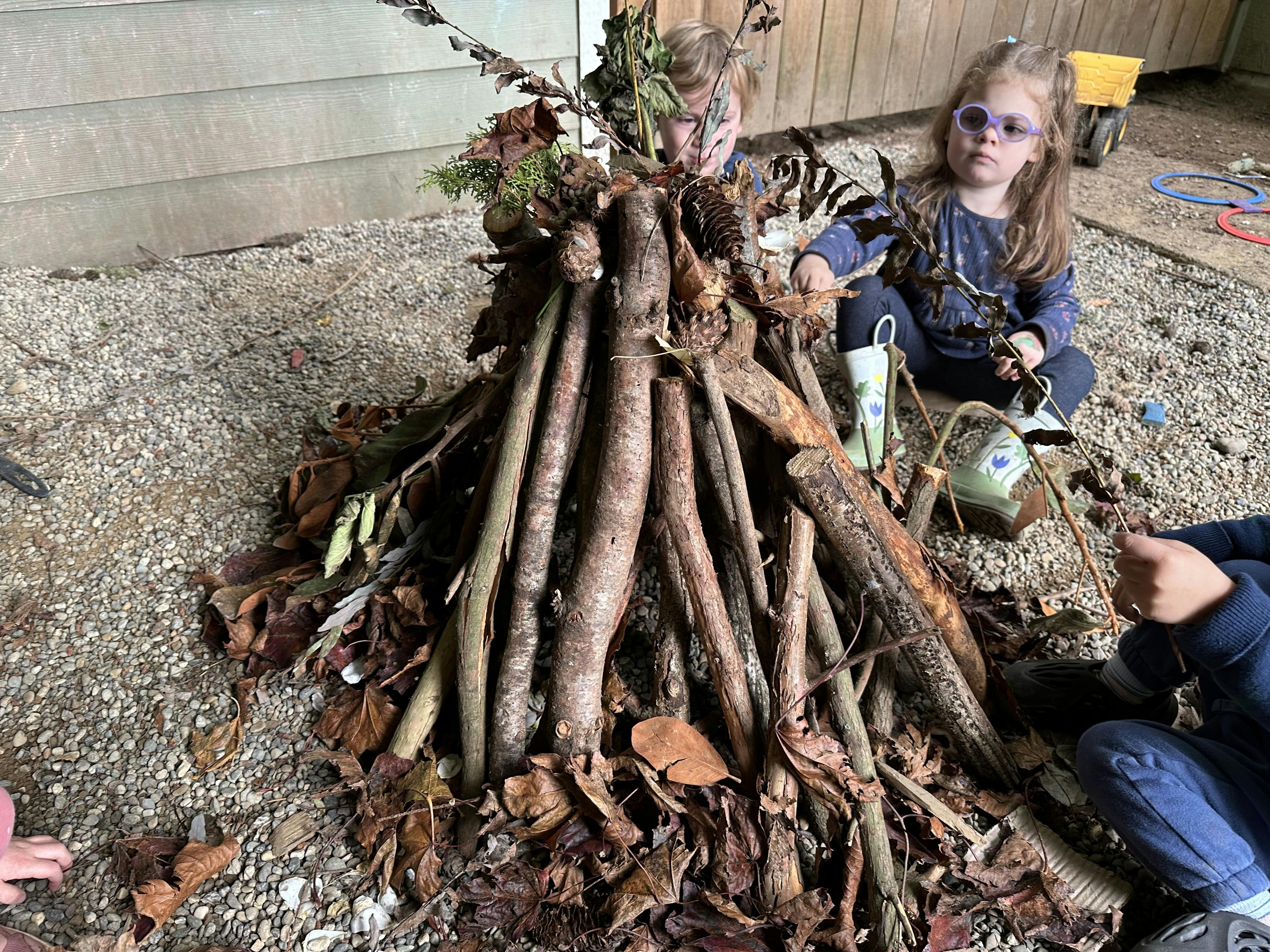 Child and teen playing with sticks and leaves