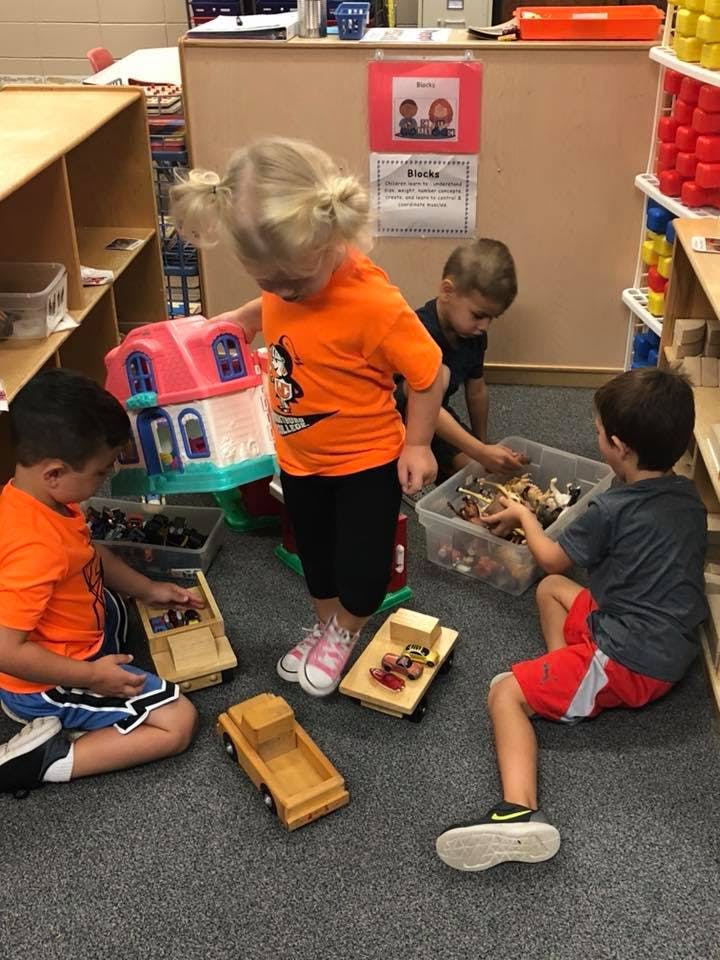 Three children playing with toys on the floor