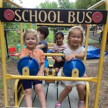 Children playing on a school bus structure at a playground