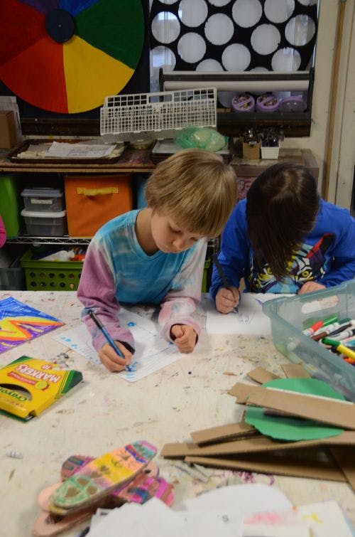 Two children drawing at a table