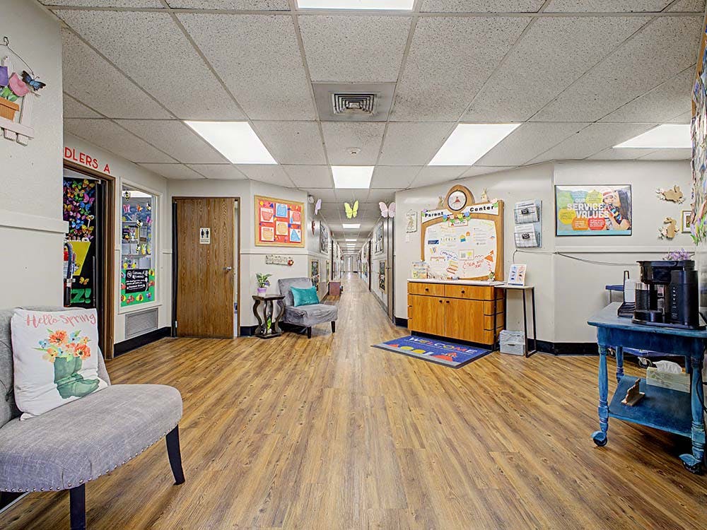 Hallway with wood floors, doors to classrooms, and a parent information center