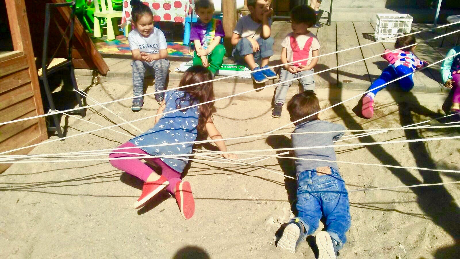 Children playing with strings on the ground
