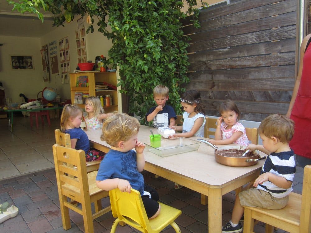 Children sitting at a table with craft supplies