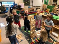 Children playing with wooden blocks in a classroom